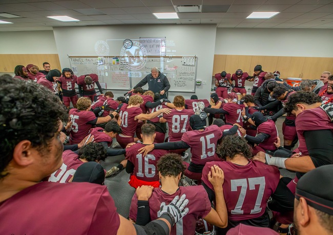 Mounties and Coach Jastrab huddle up before taking the field.